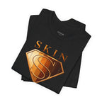 Folded black Skin Girl™ t-shirt showcasing the signature shield graphic in metallic-inspired tones.
