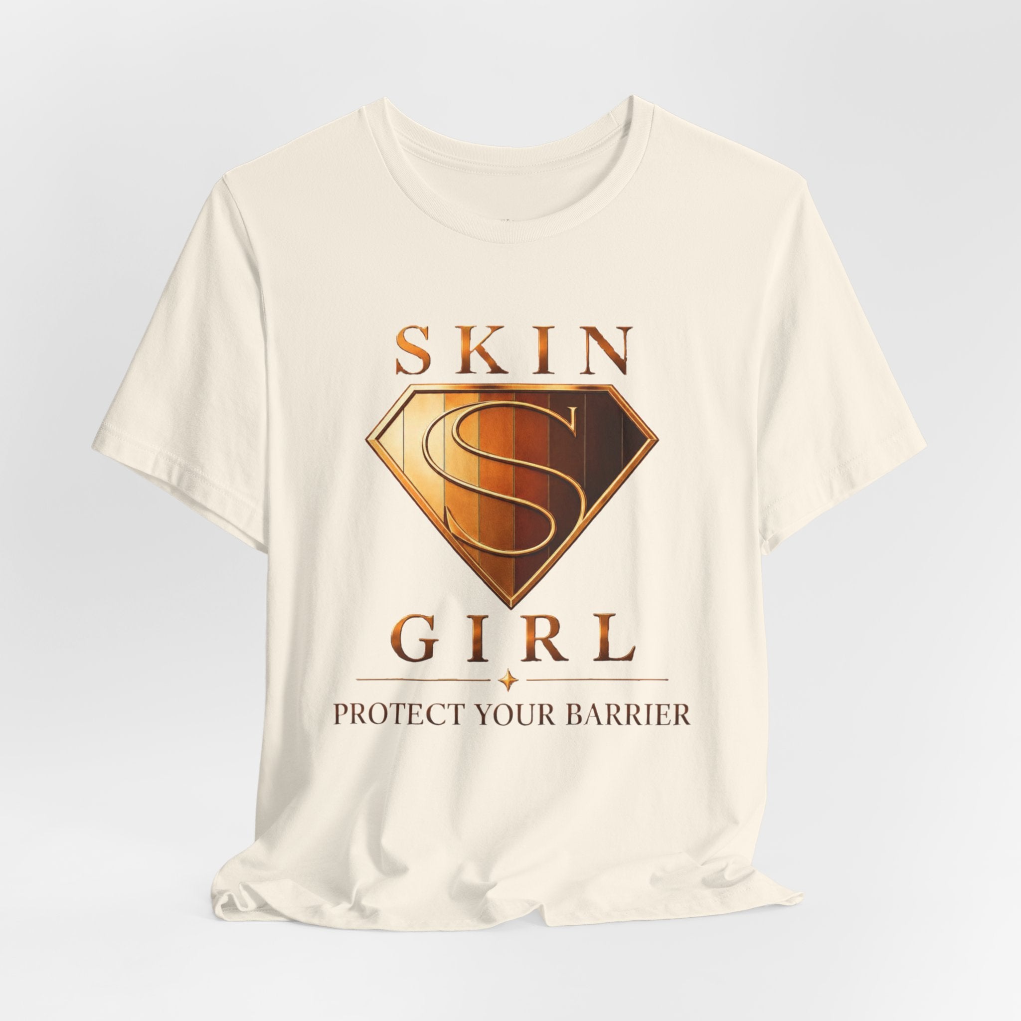Cream unisex t-shirt featuring the Skin Girl™ shield logo and the phrase Protect Your Barrier in bronze and gold tones.