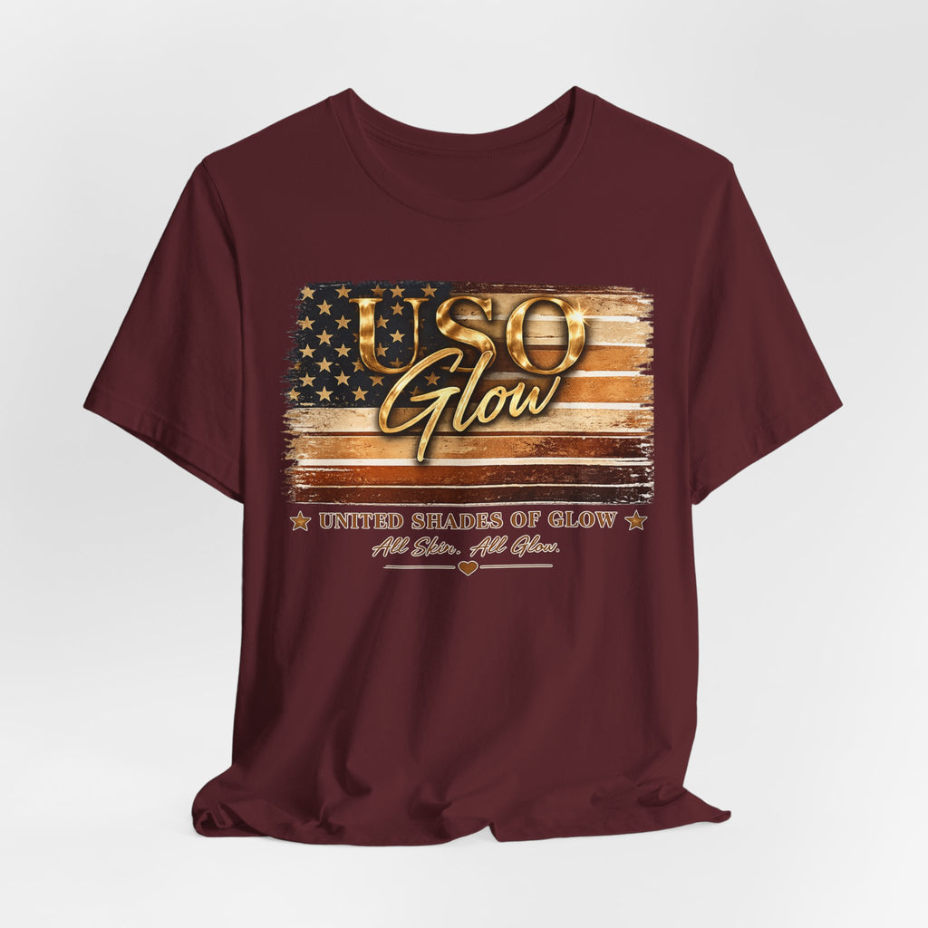 Burgundy unisex t-shirt featuring the United Shades of Glow™ graphic celebrating beauty professionals and skin confidence across all shades.
